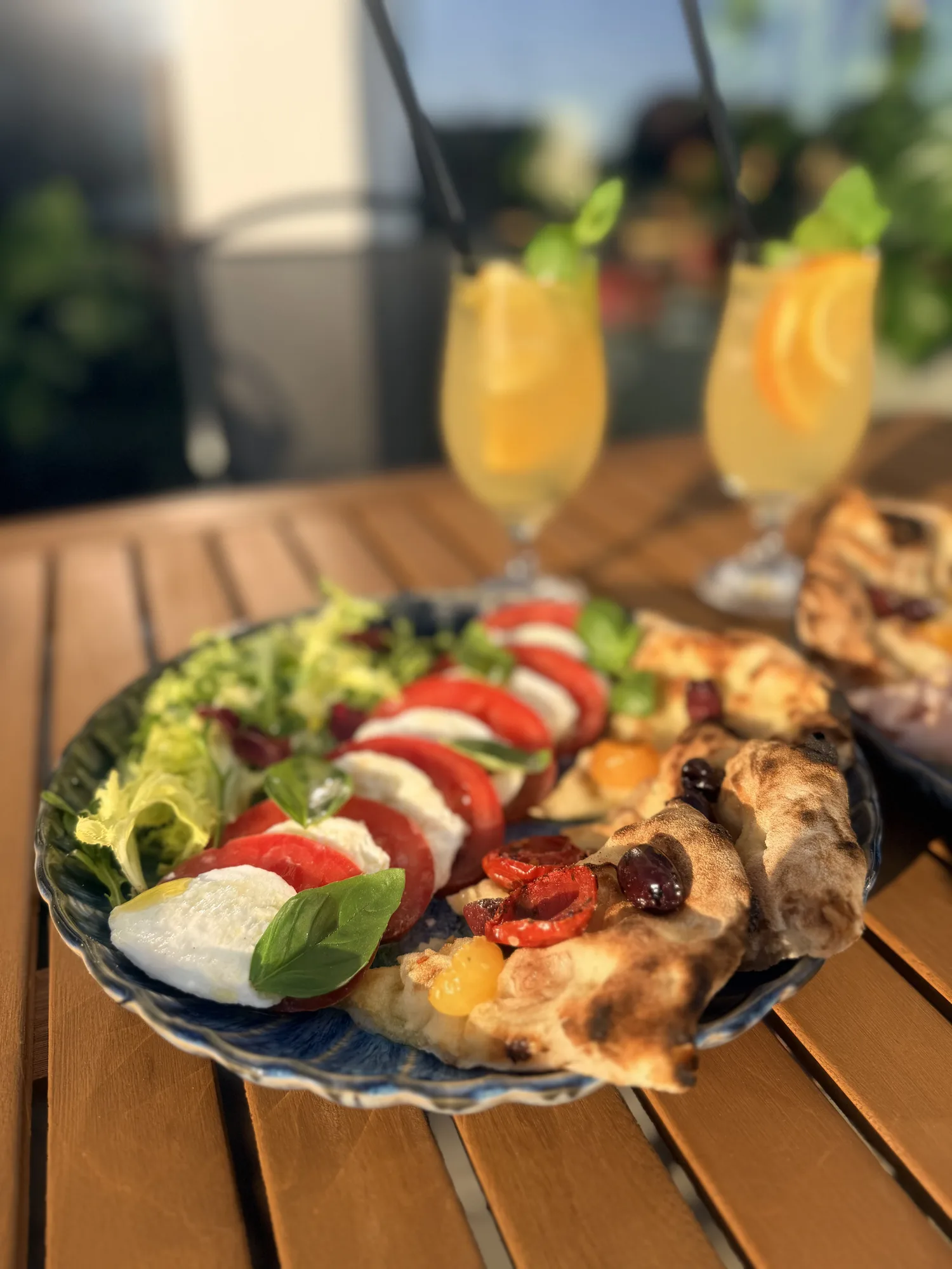 Caprese i focaccia na stoliku w ogródku, obok lemoniada